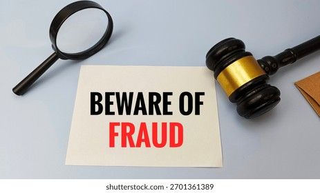 Ett papper med texten Beware of Fraud bredvid en domarklubba och ett förstoringsglas.